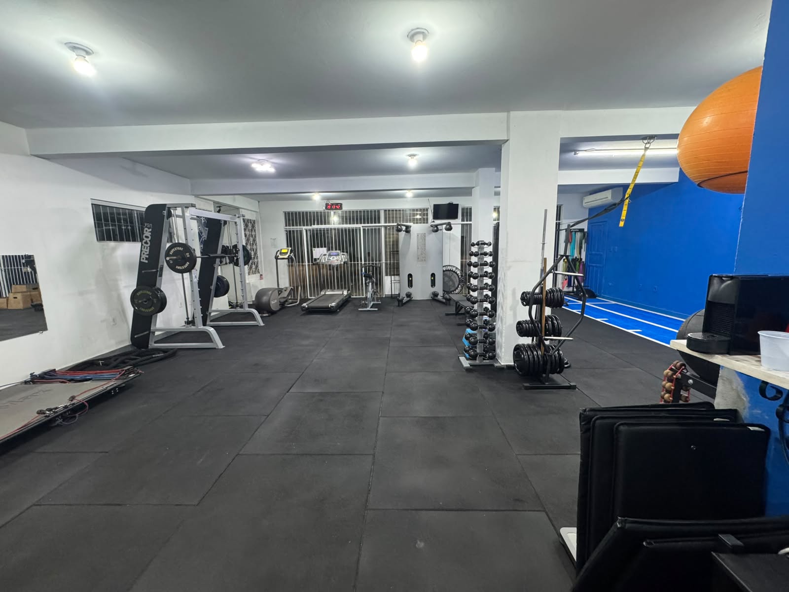 Área de treinamento funcional da unidade Rio Tavares com equipamentos, pesos e pista azul.